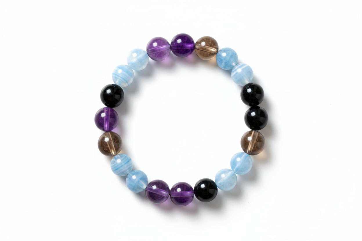 Create a premium product image of a **Natural Protection Crystal Bracelet** featuring Amethyst, Smoky Quartz, Blue Lace Agate, and Black Tourmaline beads. Arrange the bracelet neatly in a clear circular shape on a clean white background with soft shadows. Highlight the rich crystal colors and strong Shani Raksha protective energy. 1:1 square image.