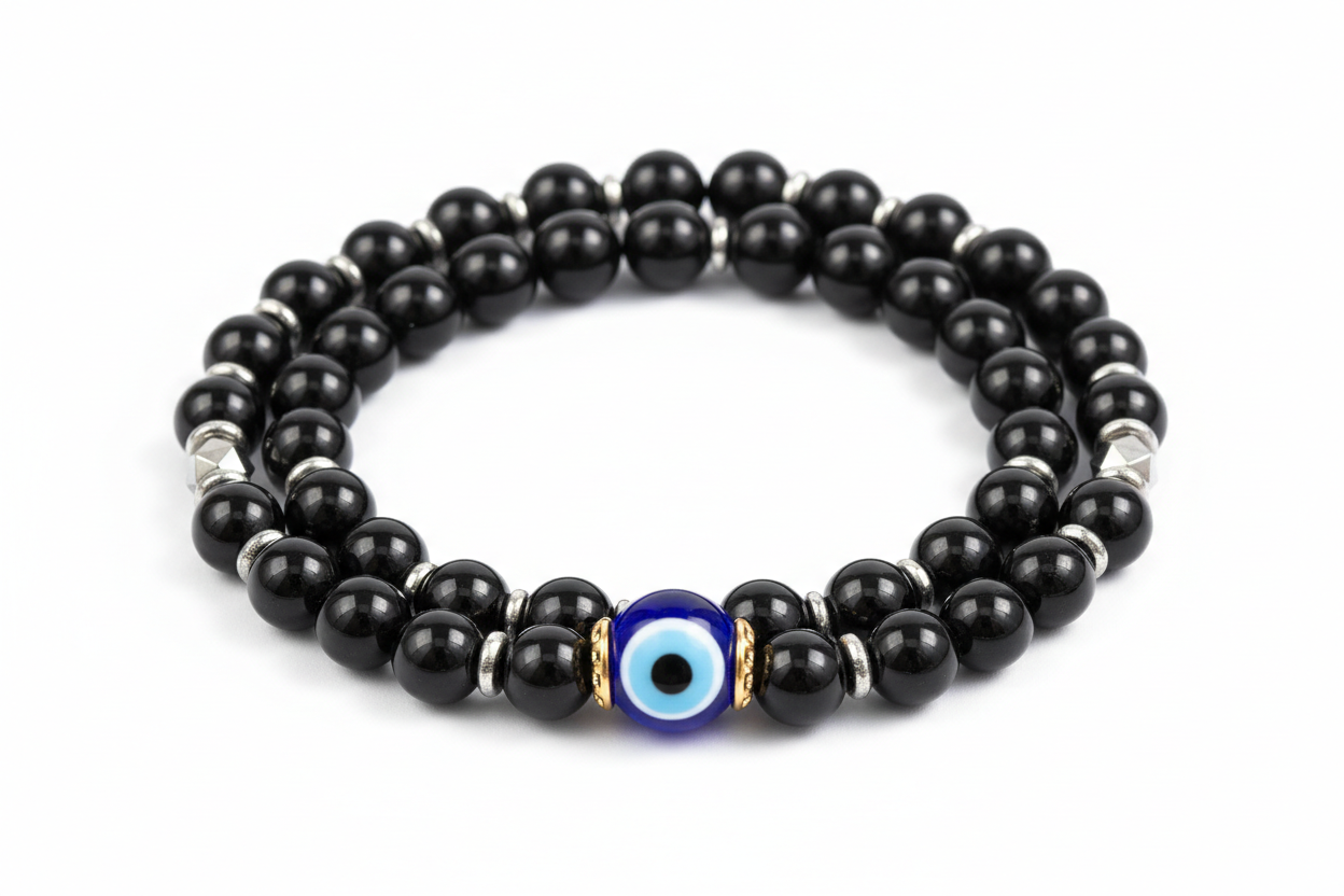 Create a premium product image of an **Evil Eye Onyx Protection Bracelet** made with black onyx, hematite beads, and a central evil eye bead. Arrange the bracelet neatly in a circular shape on a clean white background with soft shadows. Highlight the glossy black stones and strong negative-energy protection shield. 1:1 square image.