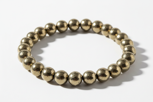 Create a premium product image of a **Pyrite Money Bracelet** made with natural pyrite “fool’s gold” crystal beads. Arrange the bracelet neatly in a circular shape on a clean white background with soft shadows. Highlight the metallic gold shine and strong wealth, abundance, and prosperity energy. 1:1 square image.
