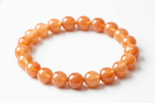 Create a premium product image of a **Sunstone Confidence Bracelet** made with natural orange sunstone beads. Arrange the bracelet neatly in a circular shape on a clean white background with soft shadows. Highlight the sparkling orange tones and its success, motivation, and solar plexus leadership energy. 1:1 square image.
