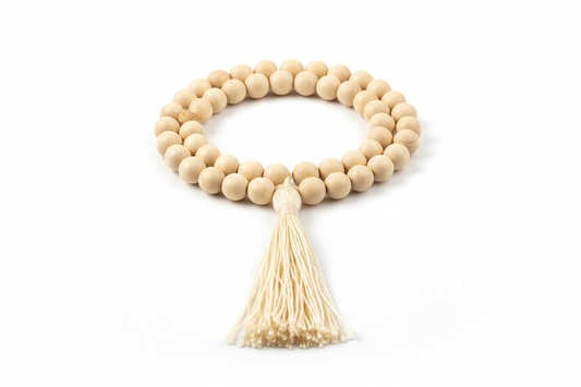 Create a premium product image of a **White Chandan Mala 8mm** made from natural sandalwood beads with a tassel. Arrange the mala clearly in a circular shape on a clean white background with soft shadows. Highlight the smooth light-wood texture and peaceful spiritual meditation vibe. 1:1 square image.
