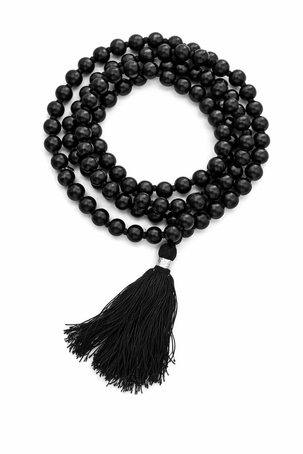 Dhivarashi black beaded mala necklace arranged in a coiled pattern with smooth round beads and black tassel on white background