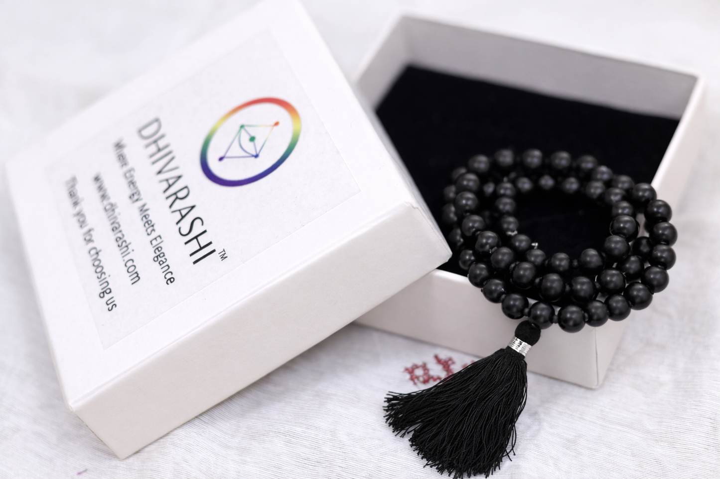 Dhivarashi black beaded mala necklace with smooth round beads and black tassel placed in a branded premium box