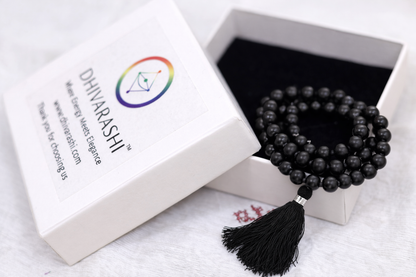 Dhivarashi black beaded mala necklace with smooth round beads and black tassel placed in a branded premium box
